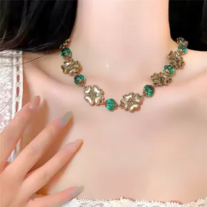 Detailed view of a vintage palace style necklace with gold flowers and green beads