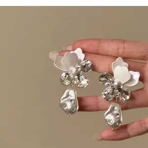 Detailopname van elegante Franse stijl bloemkristallen oorbellen met barokke parels.