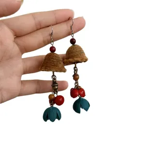 Handmade ethnic style drop earrings featuring wooden beads and brown flocked bell tassels