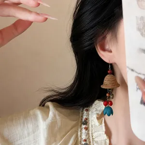 Close-up detail of vintage ethnic bell earrings featuring wooden beads and colorful tassels.
