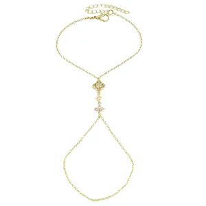 Gros plan montrant les motifs d'étoiles et de fleurs dorés de ce bracelet de main en zircon.