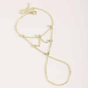 Détail du bracelet d'esclave plaqué or avec accents de zircone sur fond blanc