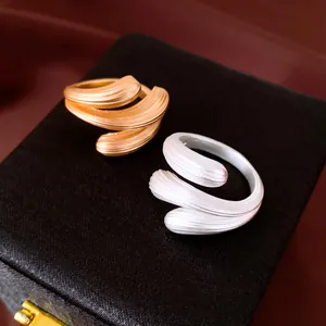 Detailaufnahme von geometrisch texturierten Wassertropfen-Ringen in Gold und Silber