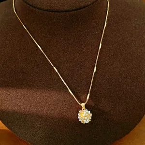 Detailansicht einer eleganten 18k vergoldeten Kette mit Perlen- und Zirkonia-Anhänger