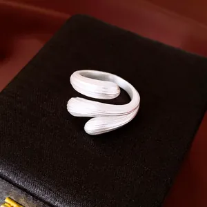 Nahaufnahme eines silbernen geometrischen Rings mit strukturierter Wassertropfenform