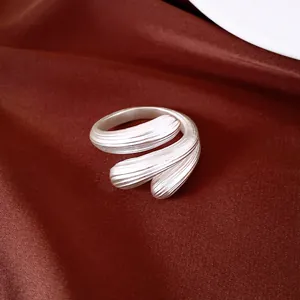 Detailansicht des gebürsteten silbernen Wassertropfen-Rings auf Seidenhintergrund