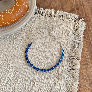 Gros plan sur un bracelet ajustable en argent serti de zircons bleus étincelants en goutte