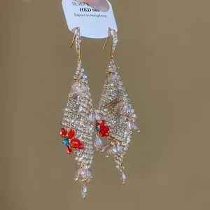 Detailansicht luxuriöser Zirkon-Quastenohrringe mit roten Glasblumen und Vergoldung
