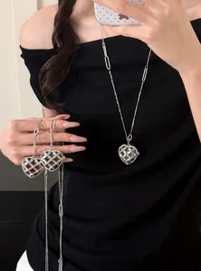 Detailweergave van hartvormige ketting met strass-steentjes op zwarte kleding