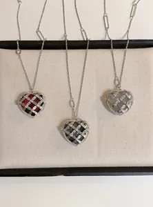 Detail van hartvormige acryl kettingen met strass kooi in drie verschillende kleuren
