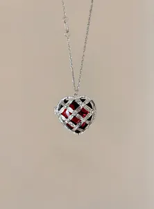 Detail van een prachtige hartvormige ketting met rode edelsteen in een zilveren strass-kooi