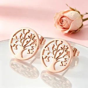 Gros plan sur des boucles d'oreilles arbre de vie évidées en or rose avec cœurs