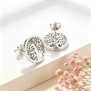 Vue détaillée du motif ajouré de l'Arbre de Vie sur des boucles d'oreilles rondes.