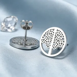 Vue détaillée des boucles d'oreilles arbre de vie en argent sur un tissu en satin bleu