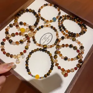 Elegante Retro-Maillard-Tigerauge- und Kristall-Perlenarmbänder auf einem Tablett präsentiert