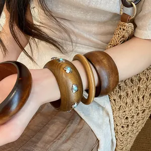 Gros plan de bracelets en bois vintage avec détails d'incrustation turquoise