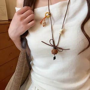 Minimalist wooden puppy pendant necklace with brown cord and handicraft beads detail
