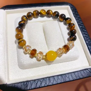 Close-up of retro tiger eye stone bracelet with faceted amber crystals in jewelry box.