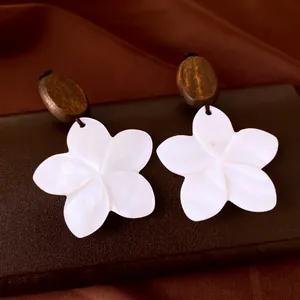 Elegant white shell flower earrings with dark wooden studs in a vintage and artistic style.