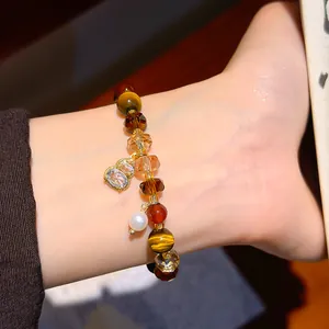 Detailed macro view of Maillard style vintage tiger eye and crystal beaded bracelet on wrist