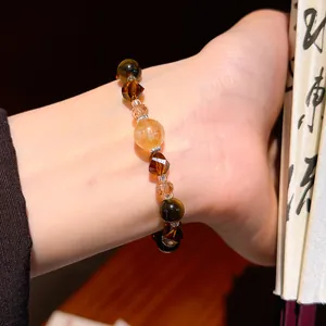 Detailed close-up of a Maillard style vintage crystal and tiger eye beaded bracelet on a wrist