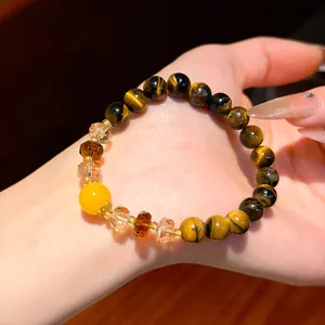 Detail view of a Maillard retro tiger eye beaded bracelet worn on a female hand