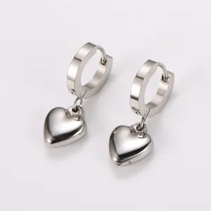 Close-up detail of silver stainless steel hoop earrings with polished smooth heart charms