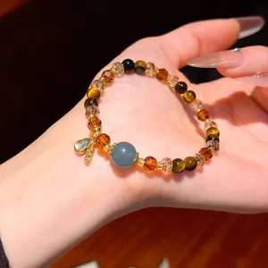 Detailed close-up showing a retro tiger eye and crystal beaded bracelet on a person's hand
