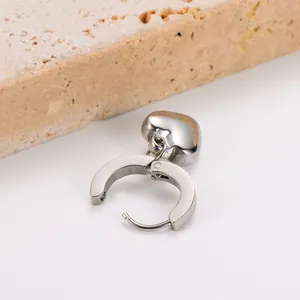 Close-up detail of minimalist silver stainless steel heart pendant hoop earring for women