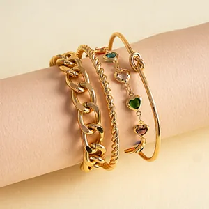 Gedetailleerde weergave van 4-delige gouden armbandset met hartbedeltjes en knoopontwerp