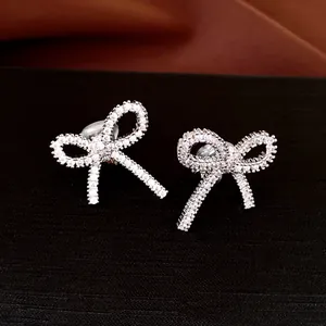 Detailed macro shot of sparkling zircon bow-shaped clip-on earrings in silver