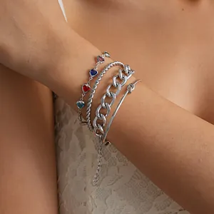 Detailopname van een 4-delige zilveren metalen armbandset met glazen hartjes.
