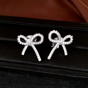 Macro detail of silver bow clip-on earrings with pave-set shimmering cubic zirconia stones