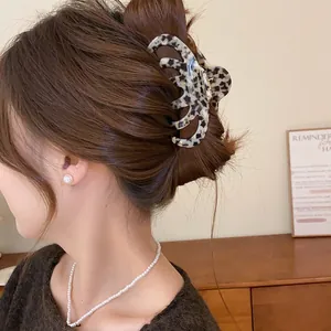 Detailansicht einer eleganten Vintage Haarklammer mit Leopardenmuster in braunem Haar