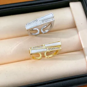 Nahaufnahme von luxuriösen Gold- und Silberringen mit Muscheleinlage und Zirkonia