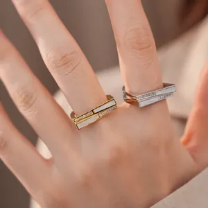 Detaillierte Nahaufnahme von zwei minimalistischen geometrischen Zirkonringen in Gold und Silber