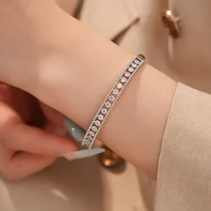 Detailansicht eines 18K weißvergoldeten zweireihigen Zirkon-Armreifs am Damenhandgelenk.