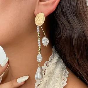 Detailansicht von eleganten Vintage-Ohrringen mit Goldmetall und unregelmäßigen Perlen.