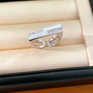 Detailaufnahme eines unregelmäßigen Silberrings mit Zirkonia und Muschel-Inlay.
