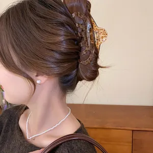 Detailansicht einer eleganten Vintage-Acryl-Haarklammer mit Leopardenmuster im Dutt