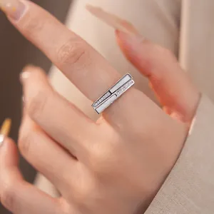 Eleganter silberner geometrischer Ring mit Perlmutt und Zirkon am Finger getragen.