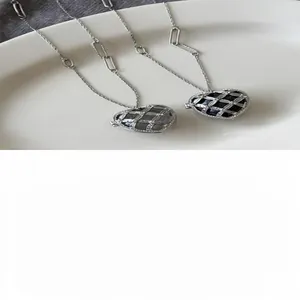 Vue détaillée de colliers pendentifs en cœur élégants avec incrustation acrylique.