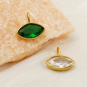 Detalle macro de colgantes de marquesa en esmeralda y circón en acero chapado oro