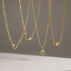Gedetailleerd overzicht van gouden roestvrijstalen kettingen met decoratieve karabijnsluitingen.