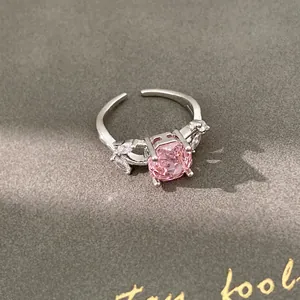 Macro detail of silver ring with a round pink zircon and marquise clear stones
