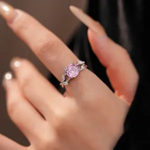 Detailed macro view of a silver ring featuring a round pink zircon and leaf-shaped side stones