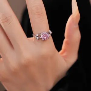 Close-up of elegant ring with pink round zircon flower and marquise leaf accents.