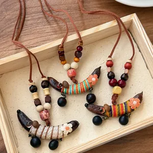 Detailweergave van handgemaakte etnische houten kralenkettingen met stoffen bonenhangers