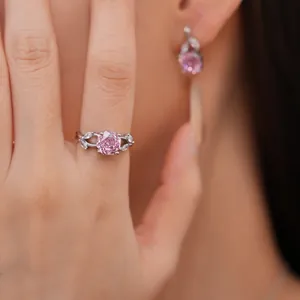 Detail of a pink rose zircon ring with silver-toned leaf design on a female hand