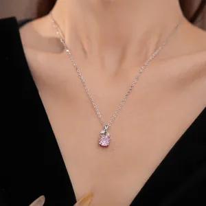 Detailed shot of a minimalist pink zircon flower pendant necklace on a silver clavicle chain